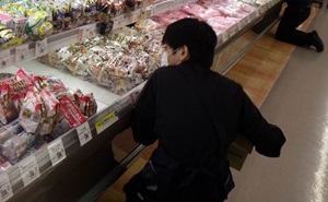 おにぎりを商品棚に並べている様子